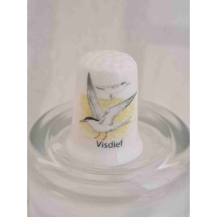 Visdief vogel op een porselein vingerhoedje