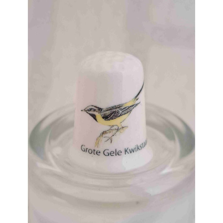 Grote gele Kwikstaart vogel op een porselein vingerhoedje