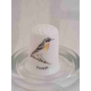 Paapje vogel op een porselein vingerhoedje