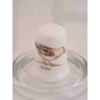 Kneu vogel op een porselein vingerhoedje