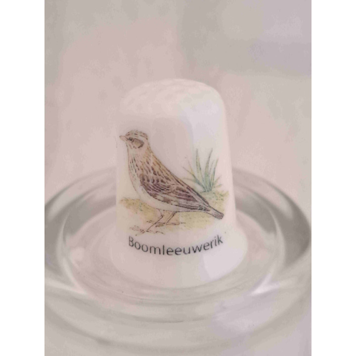 Boomleeuwerik vogel op een porselein vingerhoedje