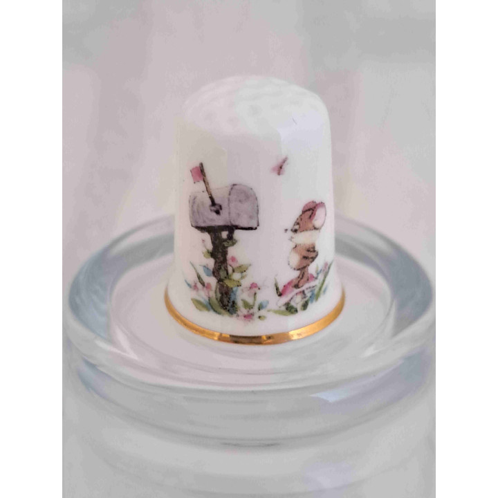 Muis met brievenbus op een porselein vingerhoedje met goud randje