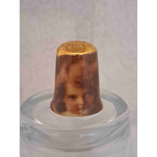 Engel meisje op een porselein vingerhoedje met goud topje