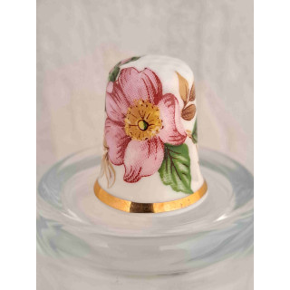 Roze bloem op een porselein vingerhoedje met goud randje