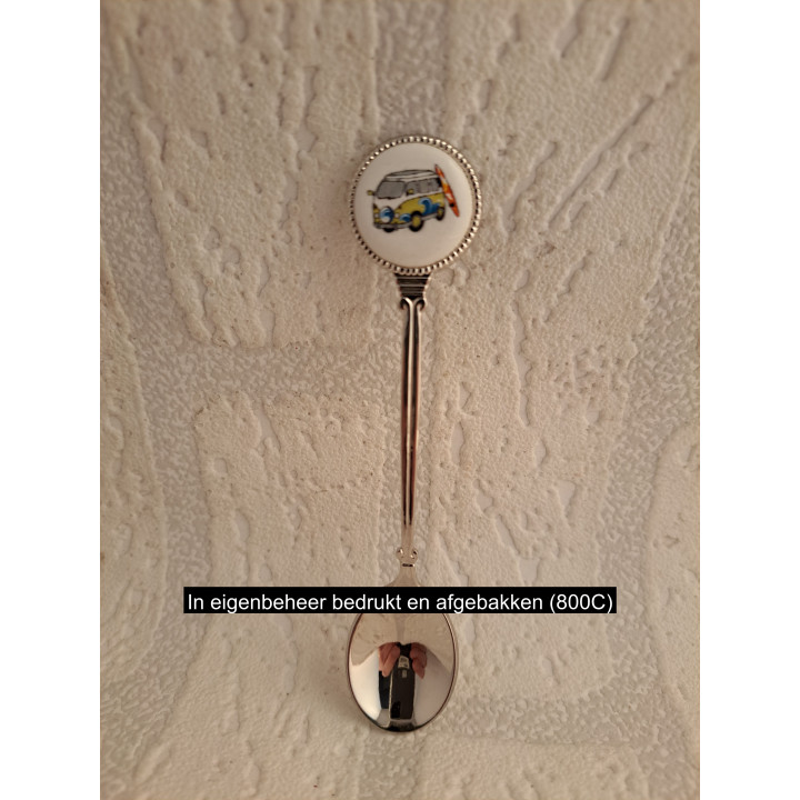 Metaal theelepeltje met groene Volkswagen met surfplank op porselein rondje