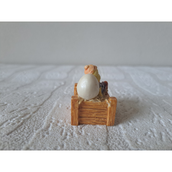 Kuiken van kunsthars zittend in krat met ei 3.5x3x4cm - dierfiguren