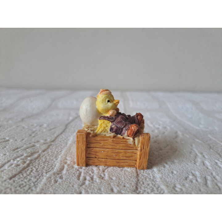 Kuiken van kunsthars zittend in krat met ei 3.5x3x4cm - dierfiguren