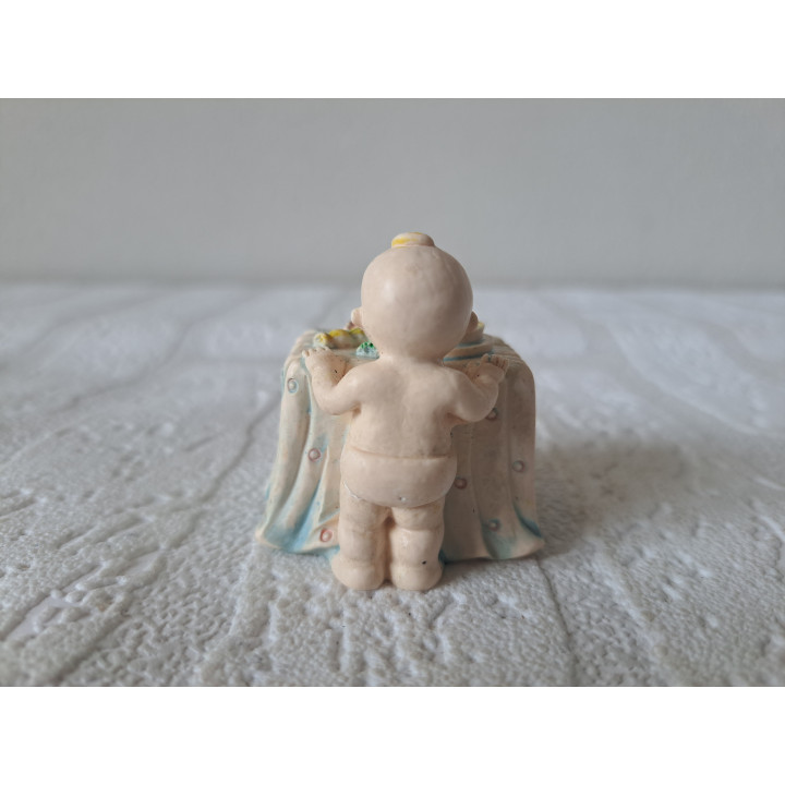 Baby van kunsthars staart naar het eten op tafel 4.5x4.5x5cm - beeldjes