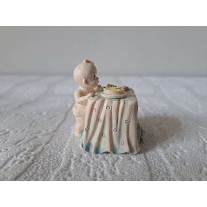 Baby Resin Figure Looking at Food on Table