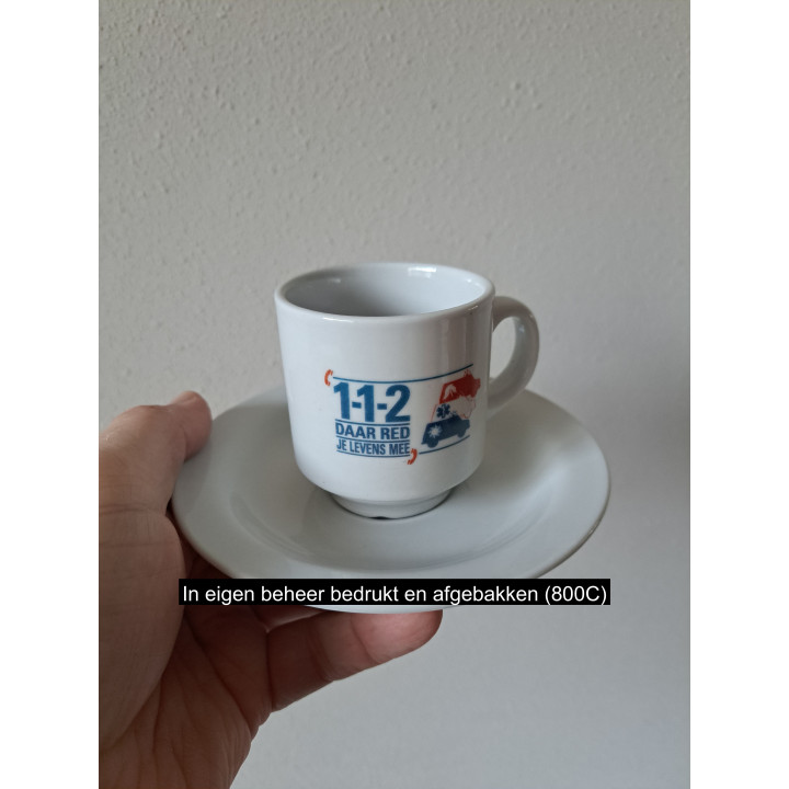 Kop en schotel 112 Daar red je levens mee, porselein D14xH8cm